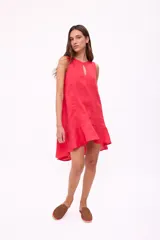 Vestido corto sin mangas color marrón chocolate, con corte holgado tipo babydoll y un pequeño ojal en el centro del escote redondo. El ruedo tiene un volante sutil.