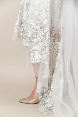 Vestido blanco irregular de tul bordado en hilo color plata y blanco, con breteles finos.