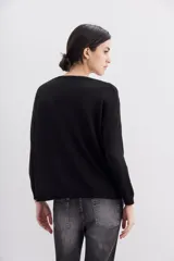 Sweater negro de manga larga y calce holgado, con terminaciones en punto rib. Presenta un bordado frontal con la frase "Tonight the night" realizado con canutillos y piedras de colores.