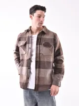 Sobrecamisa a cuadros color marrón con bolsillos frontales con solapa y cierre de botones.