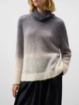 Jersey de punto cardado con diseño degradado, cuello chimenea y manga larga con hombro caído. Presenta remates en canalé en puños y bajo.