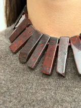 Collar de jaspe rojo natural en tonos bordeaux y rojo profundo, con piezas rectangulares dispuestas en fila y cadena de extensión dorada con dije colgante.