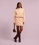 Minifalda color beige confeccionada en terciopelo cotelé, de cintura alta y corte recto.