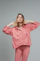 Camisa de manga larga color rosado con estampado de flores anaranjadas y blancas.