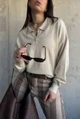 Sweater de punto color beige, con cuello polo y cierre frontal de botones, de manga larga con puños elásticos y diseño texturizado de rombos.