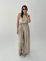Conjunto de musculosa y pantalón palazzo color dorado brillante. La musculosa es sin mangas y el pantalón es de corte ancho con cintura alta.