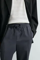 Pantalón regular fit color negro de tejido con viscosa, con cintura elástica ajustable con cordón, bolsillos frontales y traseros.