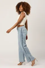 Pantalón de jean celeste de corte wide leg con licra y una franja azul marino a los costados.
