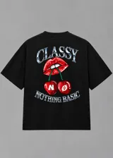 Remera boxy negra de corte holgado y mangas cortas, con estampa frontal en tono plateado con efecto metálico y detalles de labios y cerezas.
