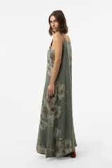 Vestido largo verde militar con estampado floral, silueta amplia y fluida, escote redondeado y breteles con detalle de botones.