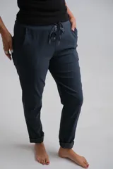 Pantalón de corte recto y ajuste cómodo, color azul marino. Presenta cintura elástica con cordón ajustable decorativo, bolsillos laterales y ruedos con dobladillo.