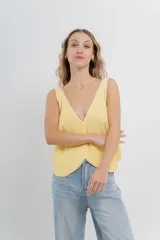 Chaleco tejido color amarillo pastel con escote en V y botones frontales.