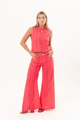 Pantalón de tiro medio y pierna amplia, con diseño a rayas en tonos rojos y rosados, bolsillos y pasacintos.