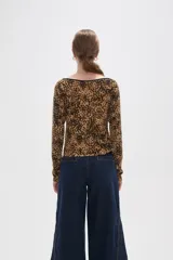 Remera de manga larga con cuello bote, confeccionada en tejido con estampado animal print tipo leopardo y borde negro en el escote.