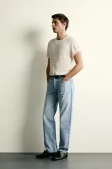 Jeans de corte recto en tono azul clásico con efecto lavado, tiro medio y diseño de cinco bolsillos con cierre frontal de botones.
