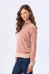 Buzo tejido combinado de color beige, con cuello alto, medio cierre metálico y puños y ruedo acanalados en tono tostado.