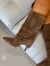 Bota de caña media en cuero gamuzado color marrón, con diseño de efecto arrugado, punta fina y taco fino.