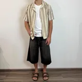 Bermuda de jean negro con corte ancho y largo a la rodilla.