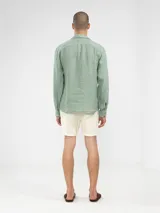 Short de hombre confeccionado en lino premium, con cintura elástica y cordón de ajuste. Presenta un diseño de corte relajado con bolsillos laterales y traseros.