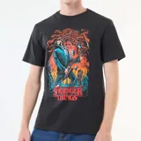 Remera negra de algodón con estampa frontal colorida inspirada en la serie Stranger Things, con diseño de personaje tocando la guitarra.