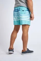 Short de baño con estampado tropical de piñas y hojas en tonos azules sobre fondo rosado. Cuenta con cintura elástica con cordón ajustable, bolsillos laterales, un bolsillo trasero y suspensor interno.
