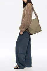 Bolso bandolera de tamaño pequeño confeccionado en nylon, con estructura blanda y cierre de cremallera. Cuenta con asa larga regulable de tejido y logo de la marca aplicado en la parte inferior frontal.