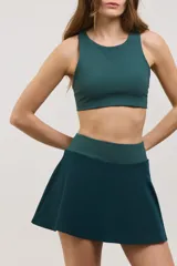 Top deportivo de sujeción media con escote redondo, diseño al cuerpo y espalda abierta. Confeccionado en tejido elastizado con elástico interno en la cintura.