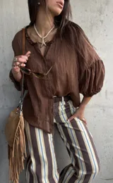 Camisa oversize color chocolate con cuello con volados, mangas abullonadas y cierre frontal con botones.