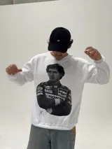 Buzo de cuello redondo color blanco, con estampa fotográfica frontal de Ayrton Senna con su traje de piloto de Fórmula 1.
