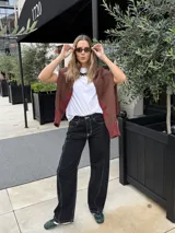 Pantalón de jean negro de corte recto y tiro medio, con costuras a contratono en color blanco.