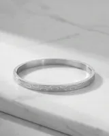 Esclava rígida de acero inoxidable con diseño de eslabones circulares grabados en toda su superficie.