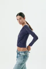 Top azul marino de manga larga con escote asimétrico y frunces laterales.