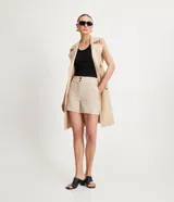 Bermuda roja de poliéster con cintura elástica, bolsillos laterales y cierre con cremallera y botones.