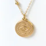 Collar doble dorado con cadena de eslabones y cadena con pequeñas esferas. Dije redondo con diseño de ojo turco.