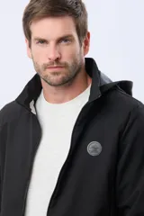 Campera negra con capucha desmontable, repelente al agua y cortaviento, con cierre frontal y parche circular con logo en el pecho.