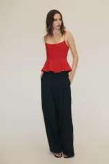 Top negro de escote redondo con tirantes muy finos y bajo acabado en peplum.