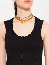 Top color borgoña de hilado frío, corte ajustado y largo hasta la primera cadera. Sin mangas, con cuello redondeado y profundo.