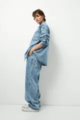 Pantalón de jean azul claro, de corte oversized y tiro bajo, con bolsillos traseros grandes.