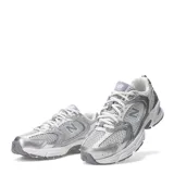 Championes New Balance 530 de estilo retro running, confeccionados con malla transpirable blanca y detalles metalizados en tono plateado. Cuentan con la icónica letra "N" en los laterales, suela amortiguada y cordones blancos.
