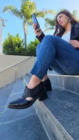 Zapatos de cuero color tostado con puntera fina y tacón bajo, estilo botineta destalonada con laterales abiertos y paneles elásticos en el empeine.