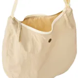 Bolso tipo morral de diseño curvo y minimalista, confeccionado en tela ligera color beige. Cuenta con cierre de cremallera superior, correa de hombro ajustable y un pequeño detalle metálico central con el logo de la marca.