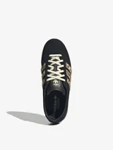 Championes Adidas Gazelle Lo Pro de perfil bajo, confeccionados en gamuza negra con las icónicas tres tiras laterales en diseño animal print de ponito y suela de goma translúcida.
