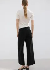 Jeans wide leg negros de tiro medio, con diseño de pernera ancha y terminación desmechada en el bajo.