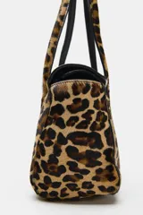 Bolso de hombro de piel con textura, diseño de estampado animal print, doble asa de hombro, bolsillo interior con cremallera y cierre mediante solapa con botón imantado.