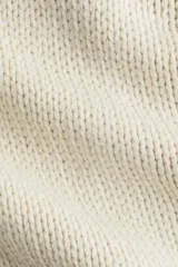 Buzo de punto con cuello redondo, manga larga raglán y detalles de costuras visibles. Presenta terminaciones acanaladas en cuello, puños y ruedo.