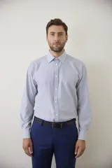 Camisa de vestir blanca de manga larga, con cuello clásico y cierre frontal de botones. Presenta un corte entallado que se adapta a la silueta.