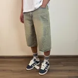 Bermuda de jean con corte baggy y largo por debajo de la rodilla, en tono azul claro lavado con efecto desgastado.