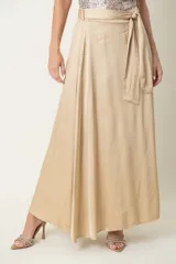 Pollera larga de satén color beige, con diseño amplio, cintura elástica y lazo ajustable del mismo tejido.