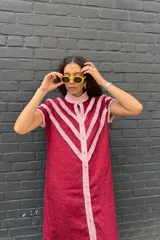 Vestido camisero midi de lino color bordó con detalles de volados rosados en forma de V en el frente y solapa central abotonada.