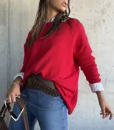 Sweater de tejido de punto en color rojo, con cuello redondo y mangas largas. Presenta un diseño holgado y cómodo.